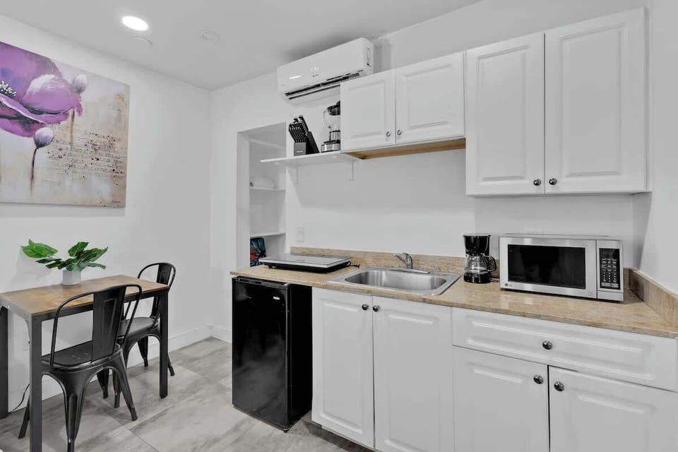 Fully equipped kitchen with dining table and AC—ideal for extended stays in a well-located Airbnb.