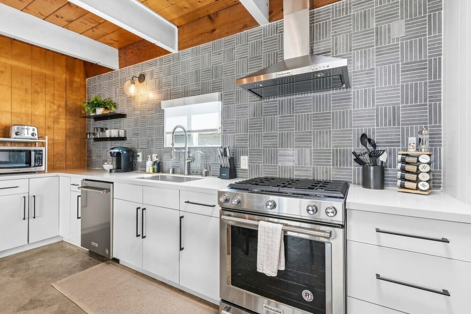 Bright kitchen and dining space with brand-new appliances, quality cookware, and seating for group meals.