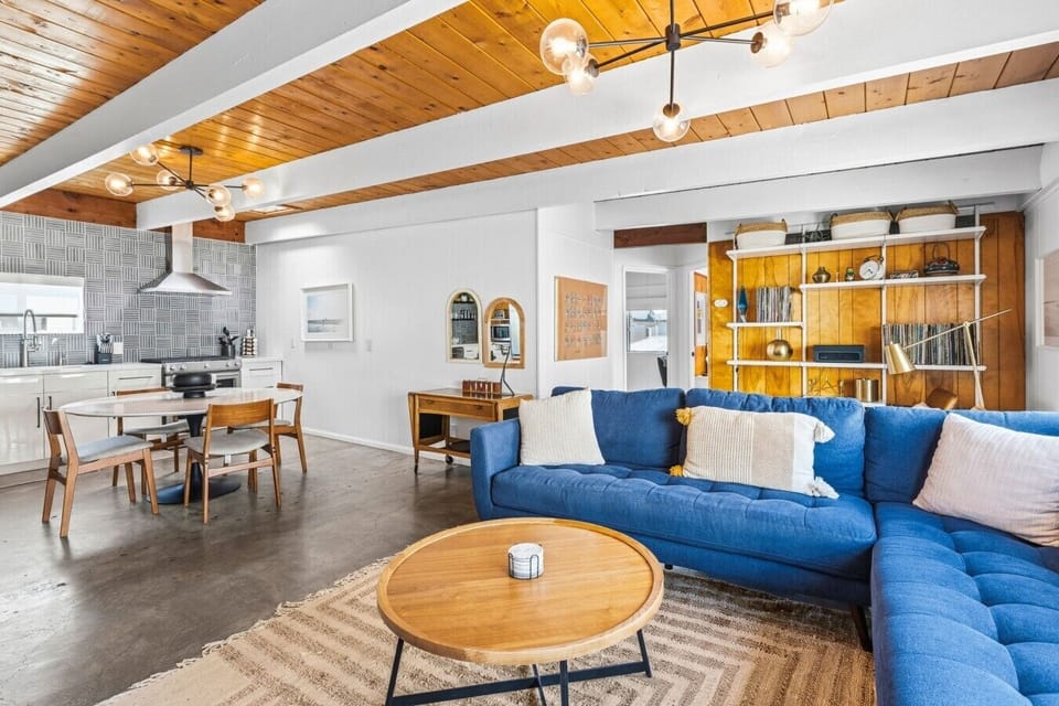 Bright open-concept living area with comfortable seating, warm wood accents, and modern coastal design.