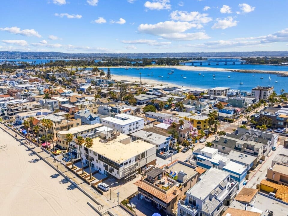 Stunning aerial overview showing the property nestled between the Pacific Ocean and the calm waters of Mission Bay.