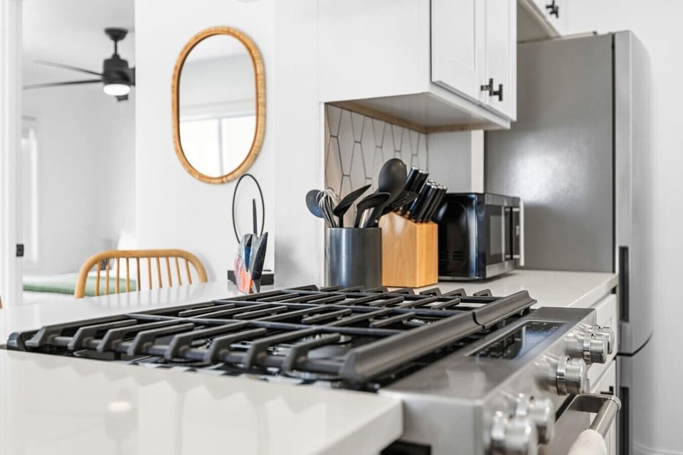Gourmet gas stovetop and sleek countertops, ready for home-cooked meals and morning coffee.
