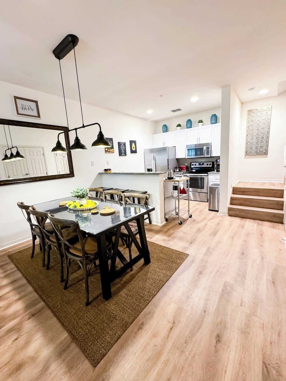 Kitchen and dining room seamlessly connected, located next to the staircase leading to the second floor.