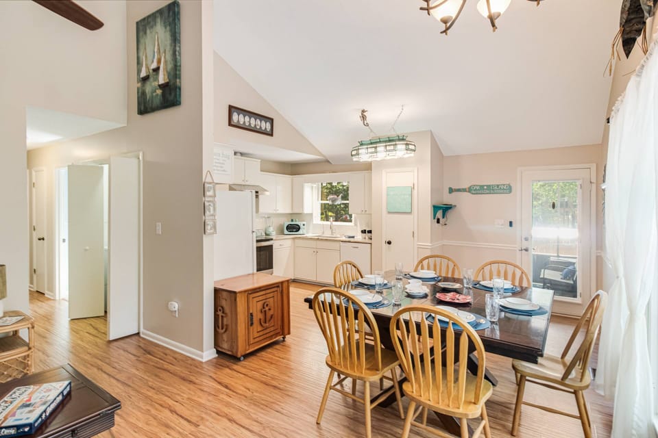 A wider view of the living room, kitchen, and hallway leading to the bedrooms.