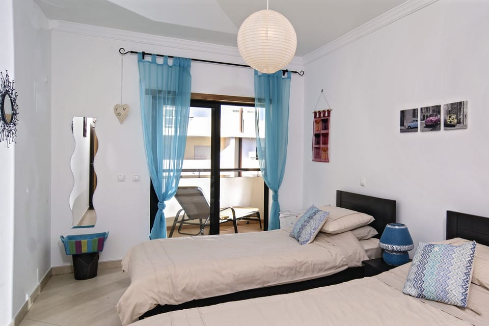 Bedroom with two single beds and direct access to the balcony