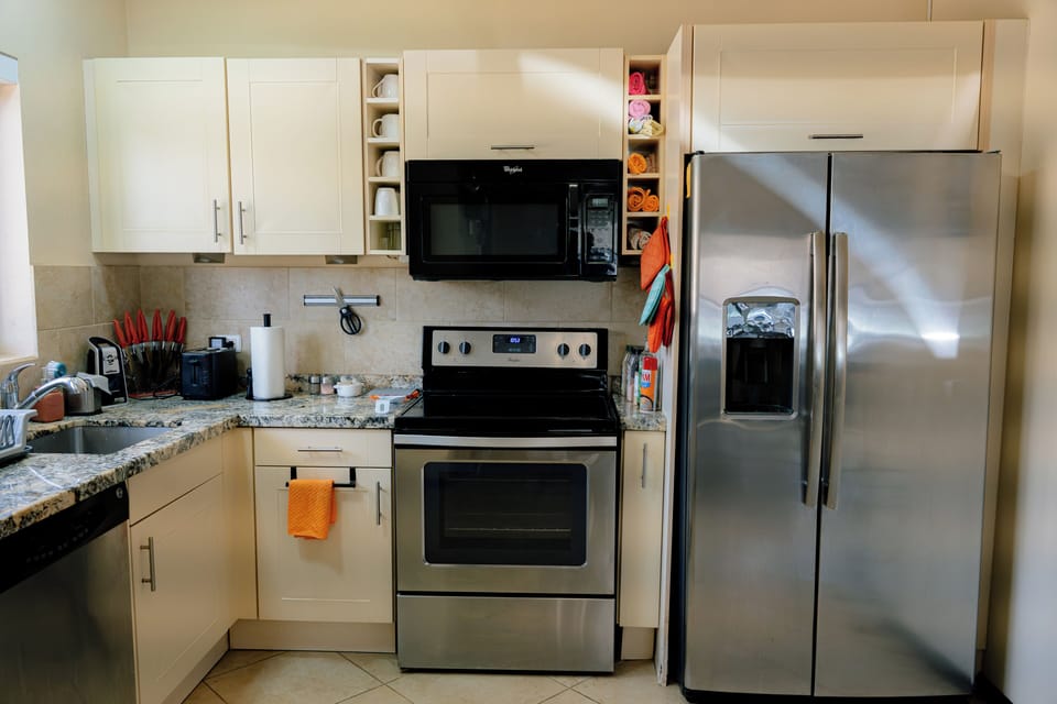 microwave, kitchen visible, indoor, instant tea pot, coffee maker, kitchen, oven, refrigerator, stovetop