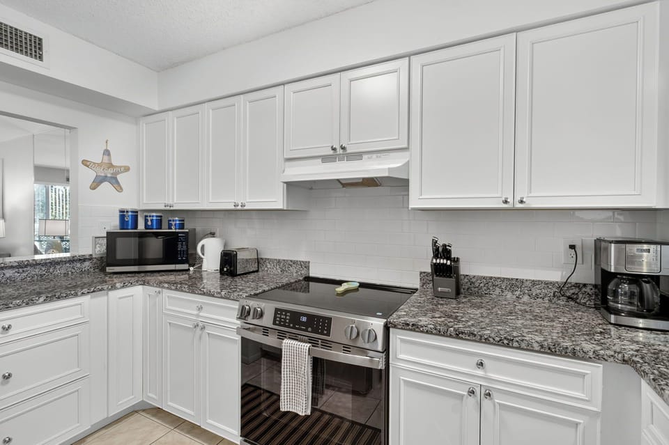Deluxe Condo | Private kitchen | Coffee/tea maker, full-size fridge, microwave, oven