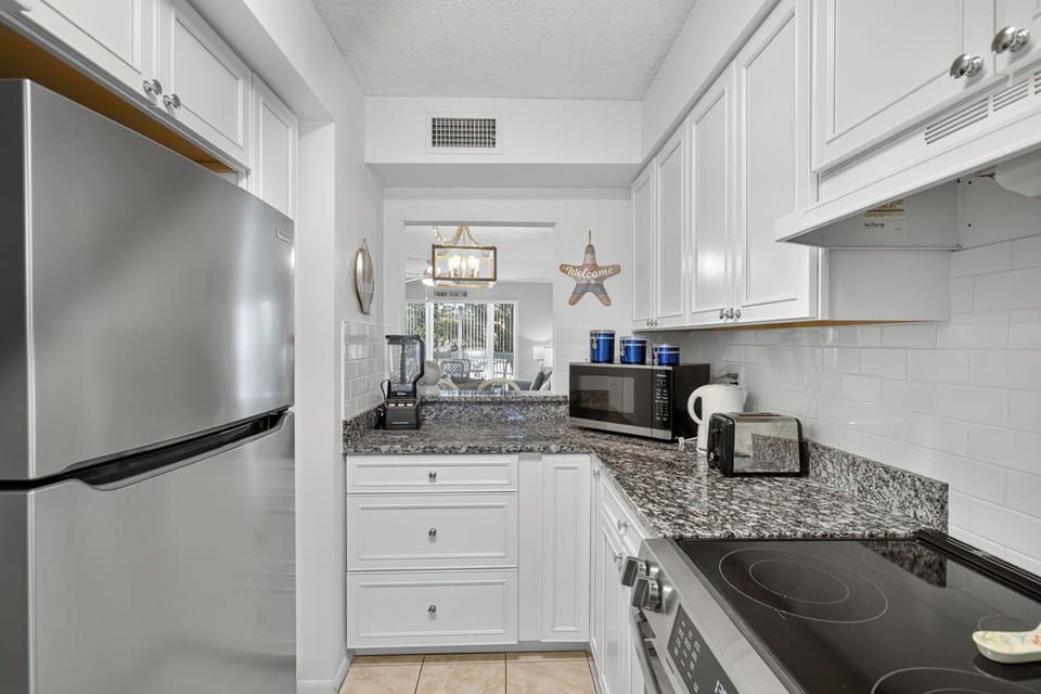 Deluxe Condo | Private kitchen | Coffee/tea maker, full-size fridge, microwave, oven