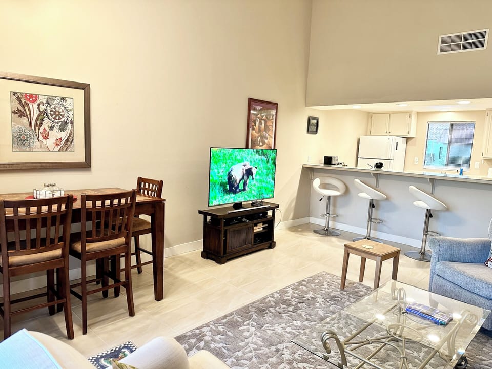 Open concept living room with Flat screen T V  dinning table and breakfast bar 