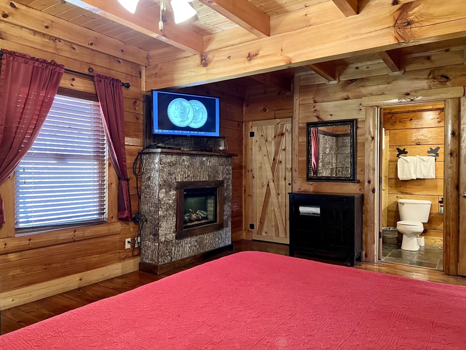View from the king bed to the year-round electric fireplace, TV and bathroom