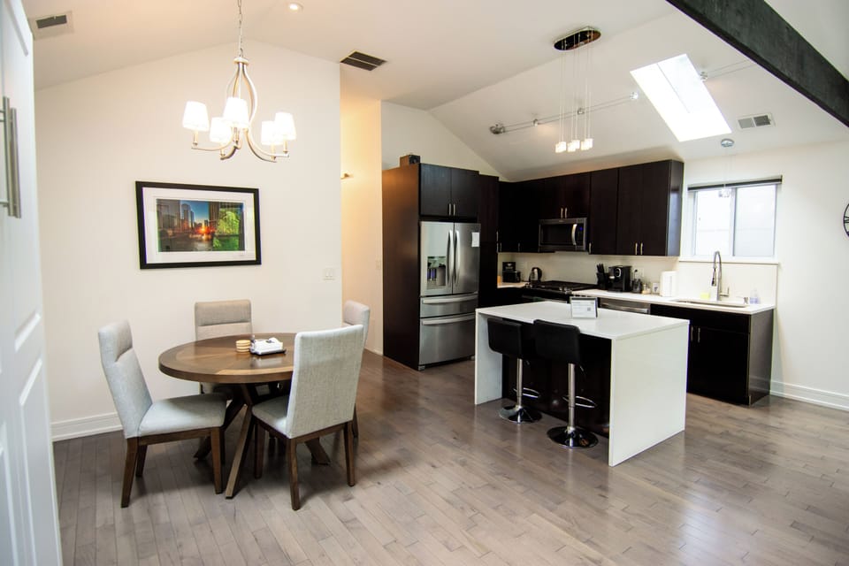 Bright modern kitchen with skylight, island seating, and cozy dining area