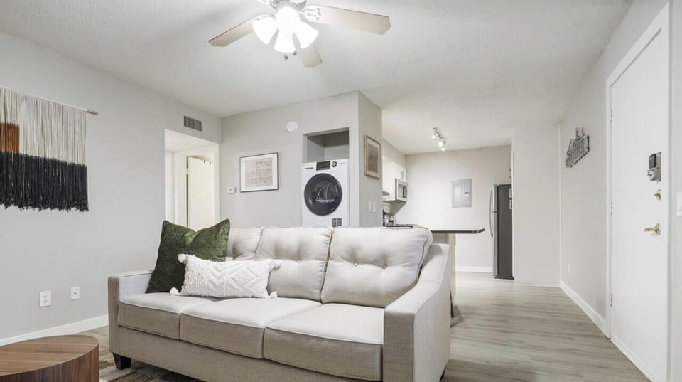 Living room with sleeper sofa, smart tv, and stacked washer and dryer