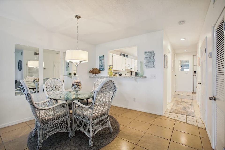 - Dining area with glass table and wicker chairs for charm  
- Overhead lighting brightens the welcoming dining space  
- Open layout connects to kitchen for easy meal serving  
