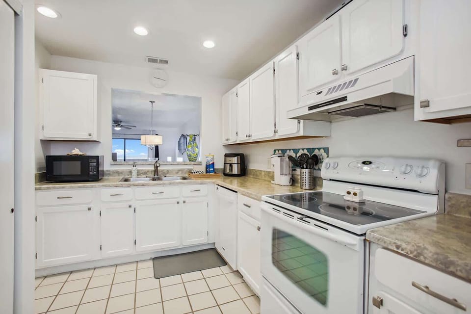 - Alternate kitchen view with smooth counters and storage  
- Overhead lighting keeps the space bright and efficient  
- Ready for family meals with modern cooking essentials  