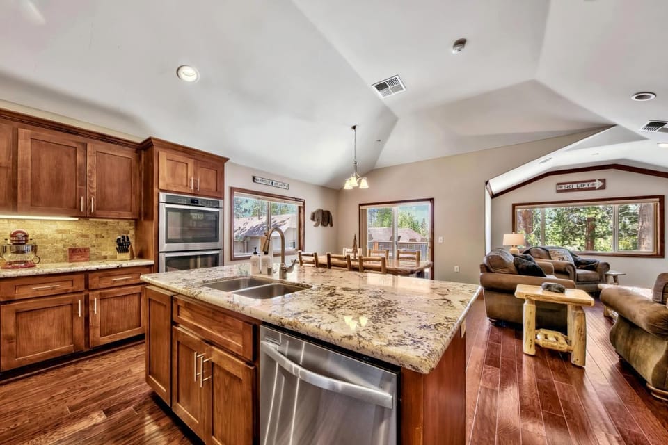 Your open-concept kitchen flows seamlessly into the cozy living space, featuring granite countertops and warm wood finishes perfect for gathering.
