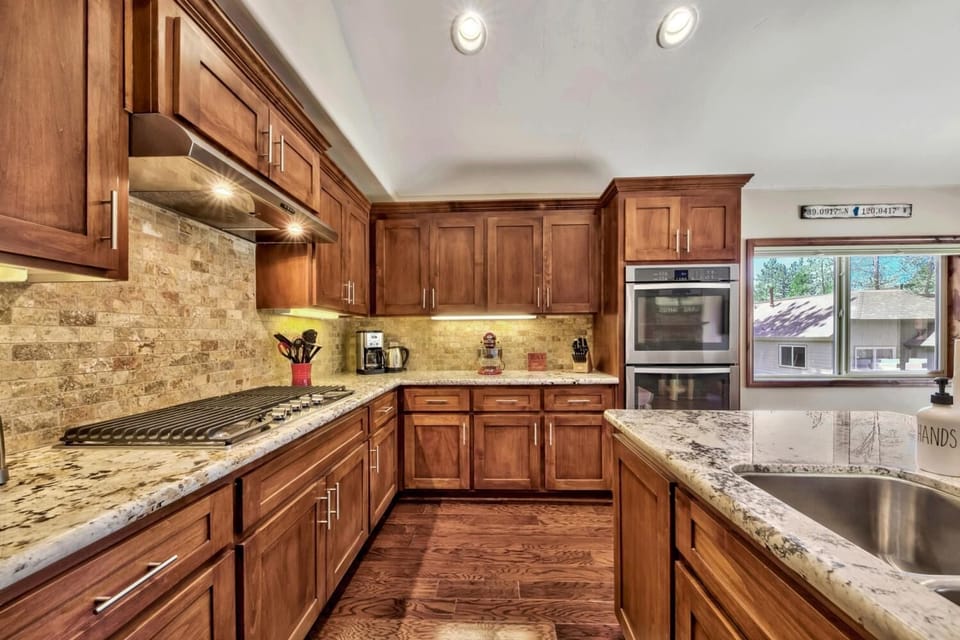Your gourmet kitchen awaits with rich wood cabinetry, granite counters, and premium appliances - perfect for creating memorable meals together.