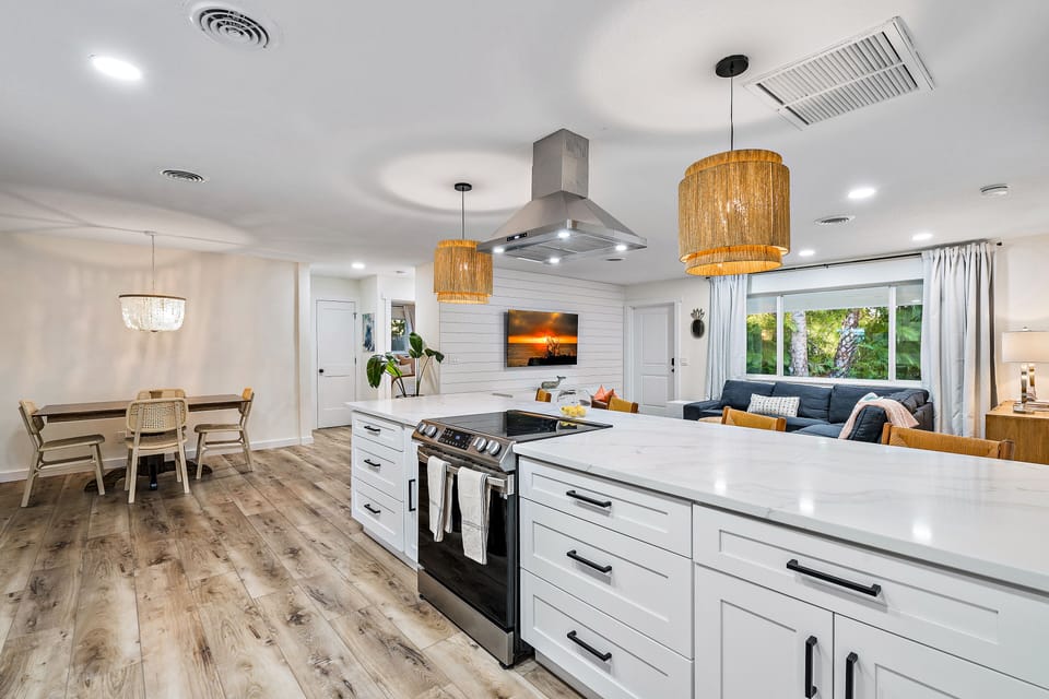 Modern coastal open kitchen with stainless steel appliances and disposal.