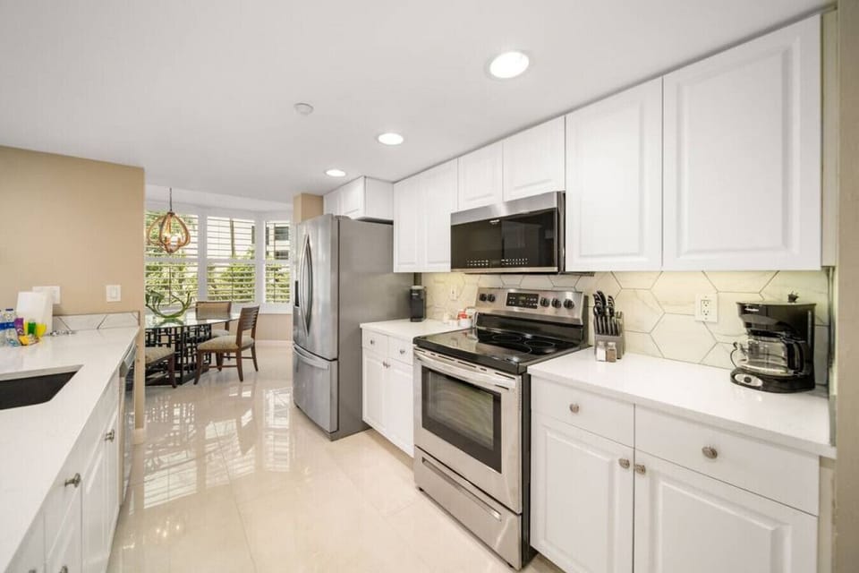 Other view of the kitchen area with oven, ref, microwave oven and coffee maker