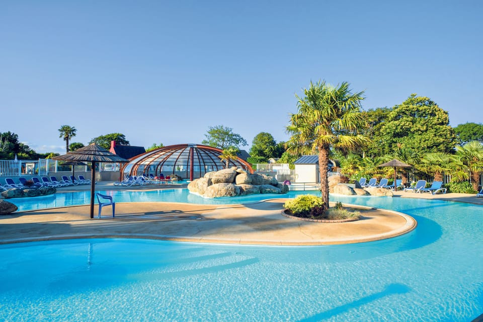A refreshing outdoor pool surrounded by trees, perfect for sun-soaked relaxation.