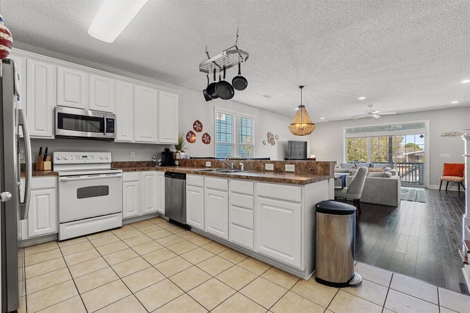 Your fully equipped kitchen features white cabinets, granite counters, and stainless appliances—perfect for preparing memorable vacation meals together.