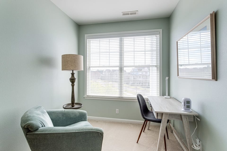 Office alcove with work desk and cozy reading chair.