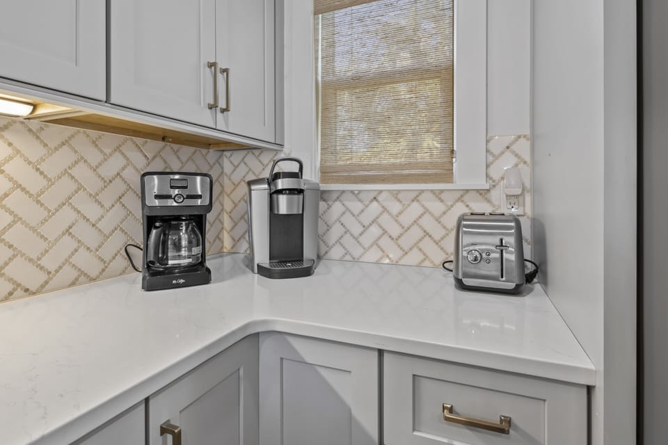Start your mornings right in this stylish kitchen corner with a coffee maker, Keurig, and toaster ready for your perfect breakfast.