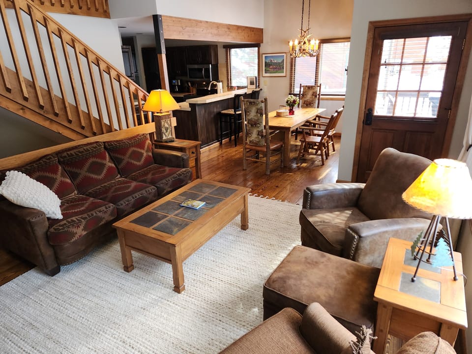Great room with vaulted ceiling opens to the dining room and kitchen.