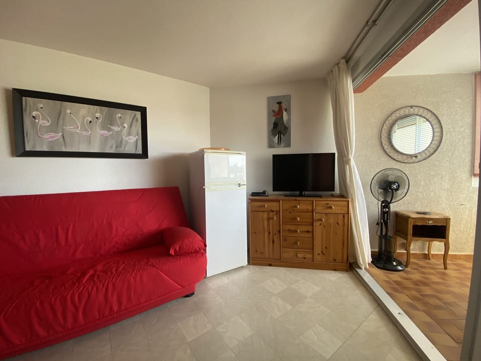 The sitting area, equipped with a sofa bed for two people, also offers a view of the closed loggia, where there is a space dedicated to the dining room