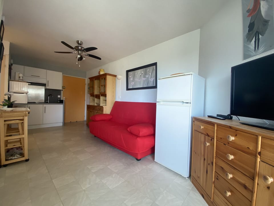 The living area includes a comfortable sitting area and a fully equipped open plan kitchen with all the necessary amenities to spend a pleasant stay, such as a refrigerator, oven, microwave, kettle, etc