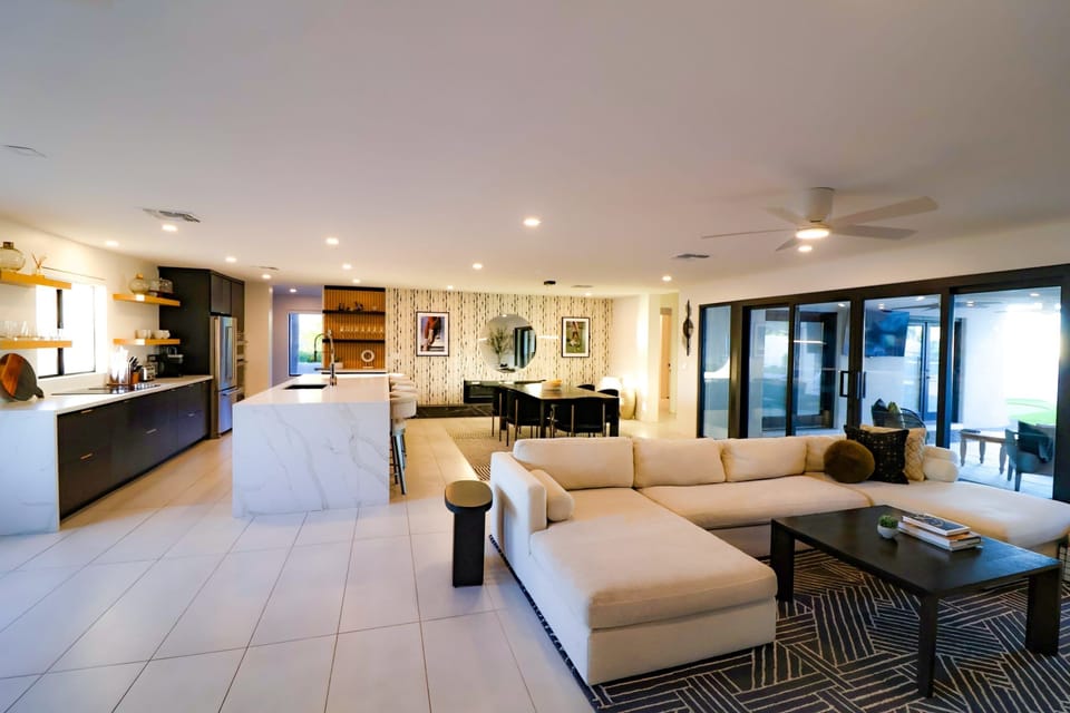 Spacious great room featuring a large sectional sofa, abundant natural light, a large HDTV with cable, and board games for added fun!