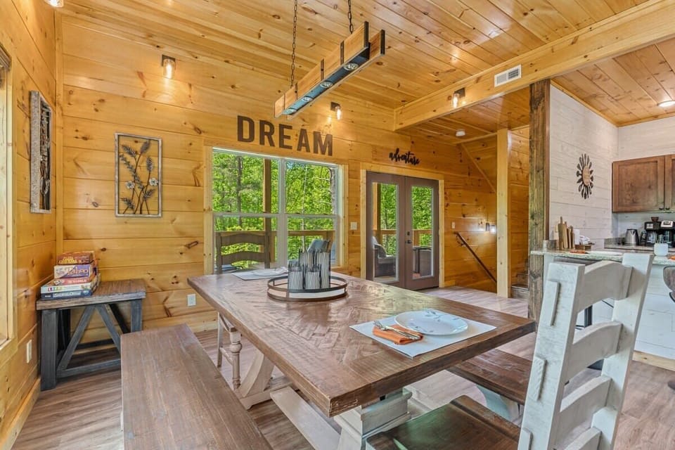 Rustic dining area with wooden table and forest views through large windows