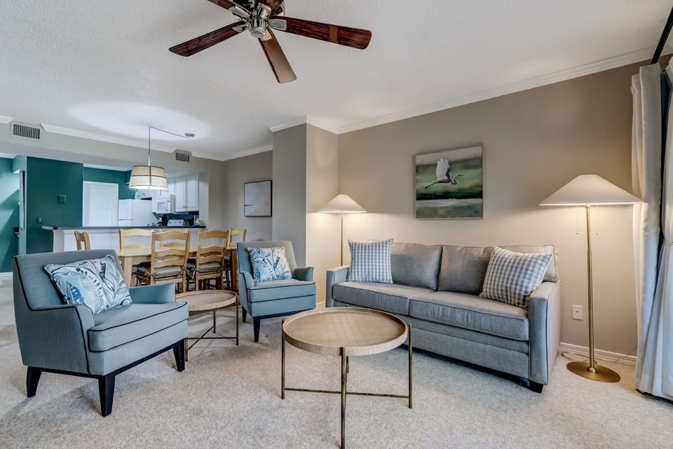 Living Space with Two Chairs and a Sleeper Sofa Situated around a Large Flat Screen Smart TV