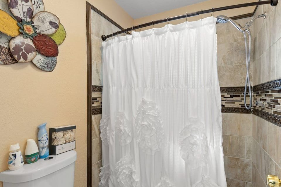 Master bathroom standing shower and toilet.