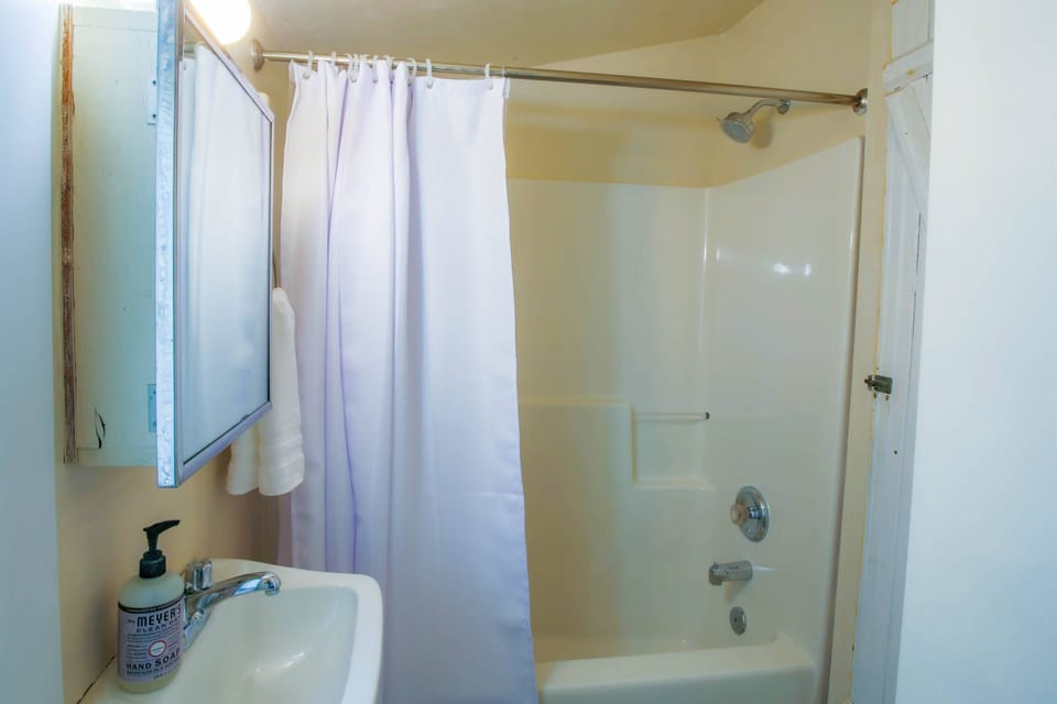 The second bathroom has a vanity and shower/tub combo.