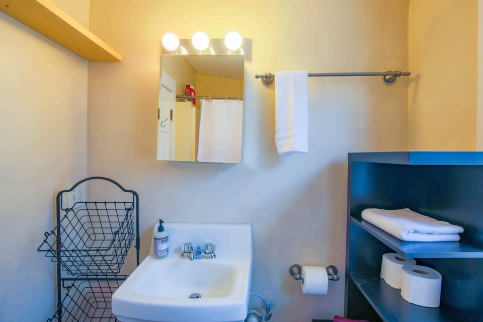 The en suite bathroom has a vanity, medicine cabinet and storage area.