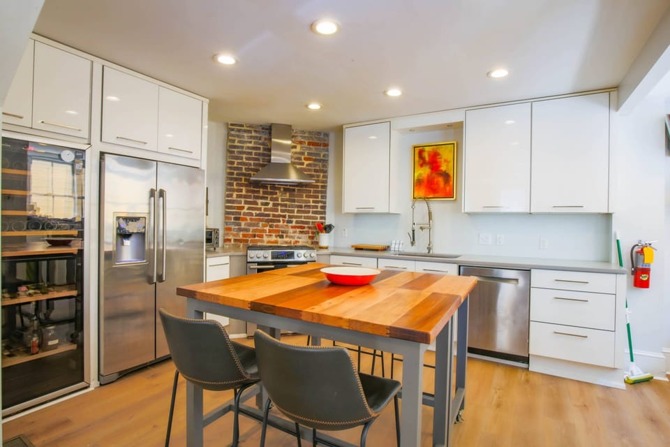 The kitchen features stainless steel appliances, white cabinets and new flooring.