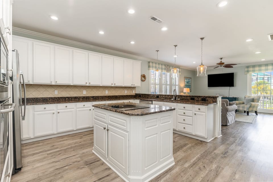 Cook your favorite meals in this stunning kitchen featuring granite countertops, white cabinetry, and a spacious island perfect for gathering.