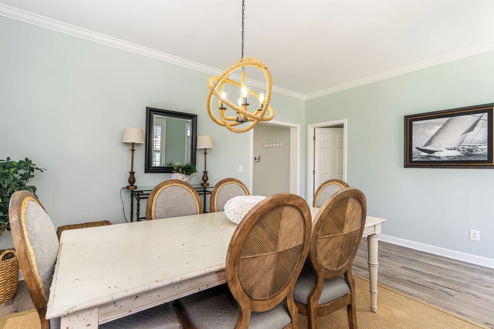 Gather around your elegant dining table beneath the stunning chandelier for memorable meals with loved ones.