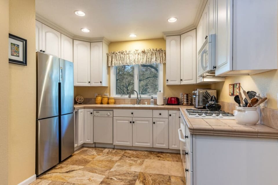 Kitchen with full fridge/freezer, small dishwasher, and gas burning stove.