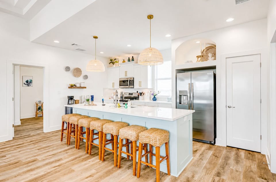 Modern kitchen with large island, bar seating, stainless steel appliances, and open layout—perfect for entertaining in this Texas beach house.