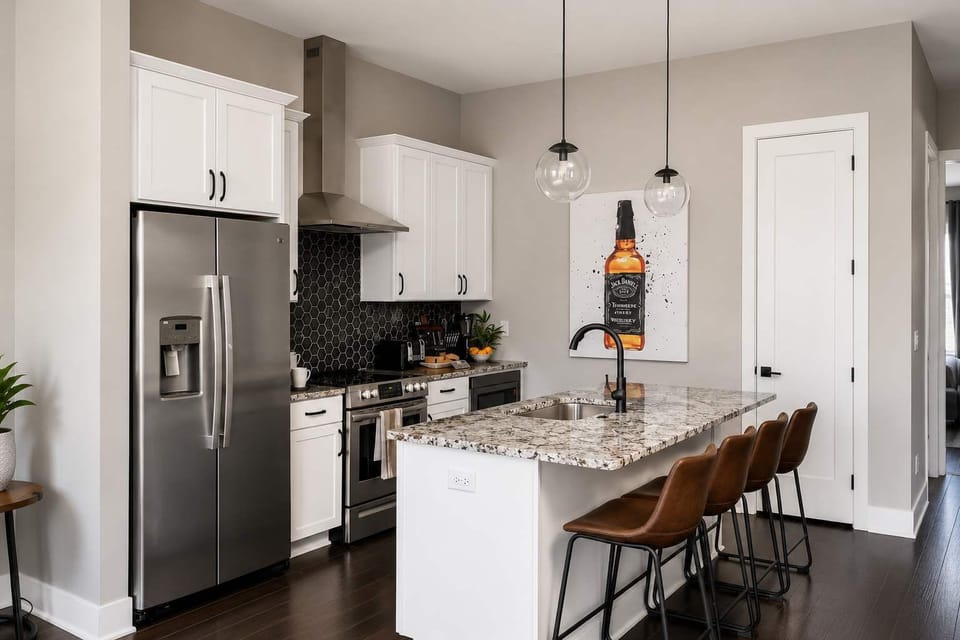 Sleek, fully equipped kitchen featuring stainless steel appliances and marble countertops.
