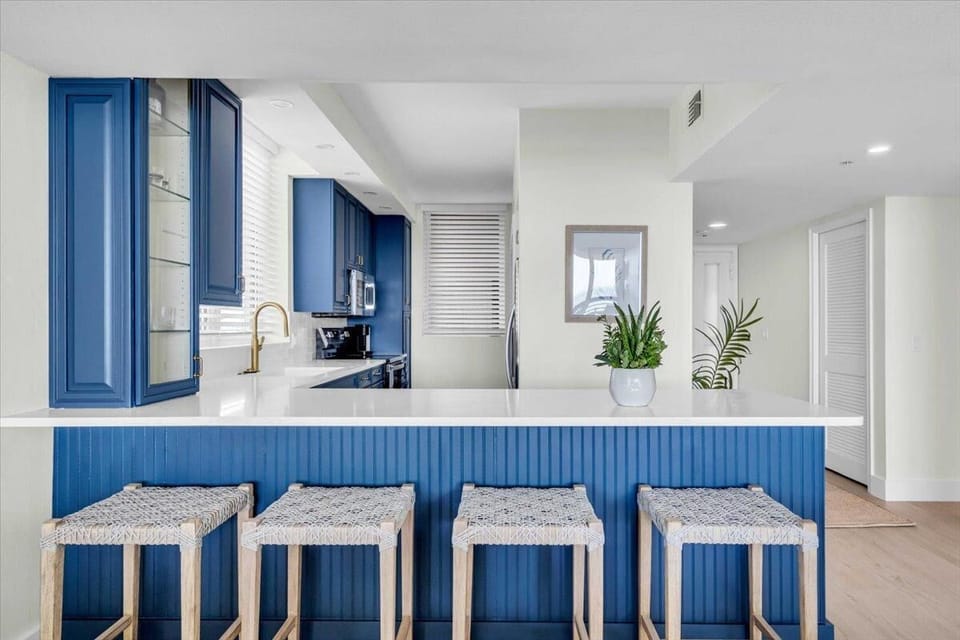 Modern kitchen with vibrant blue cabinetry and breakfast bar seating