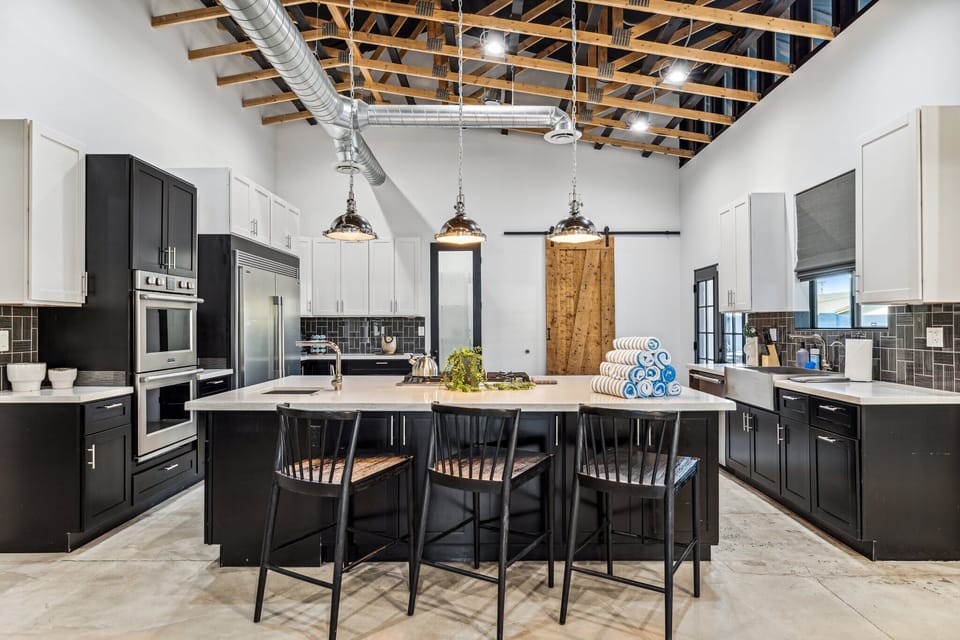 Large kitchen with island seating. 2 ovens, 2 sinks, SubZero Fridge and freezer. Walk in pantry and east patio access. 