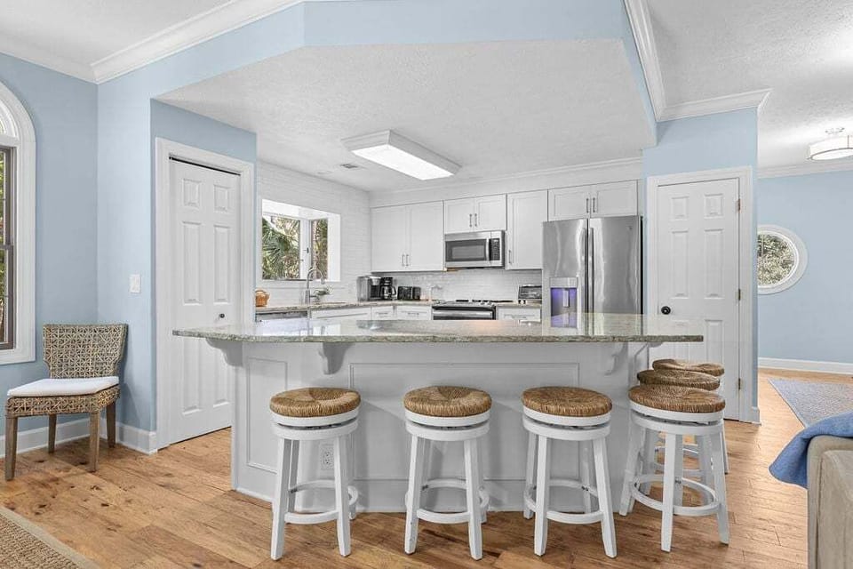 The kitchen is open to both the dining and living areas. The large island seats six.