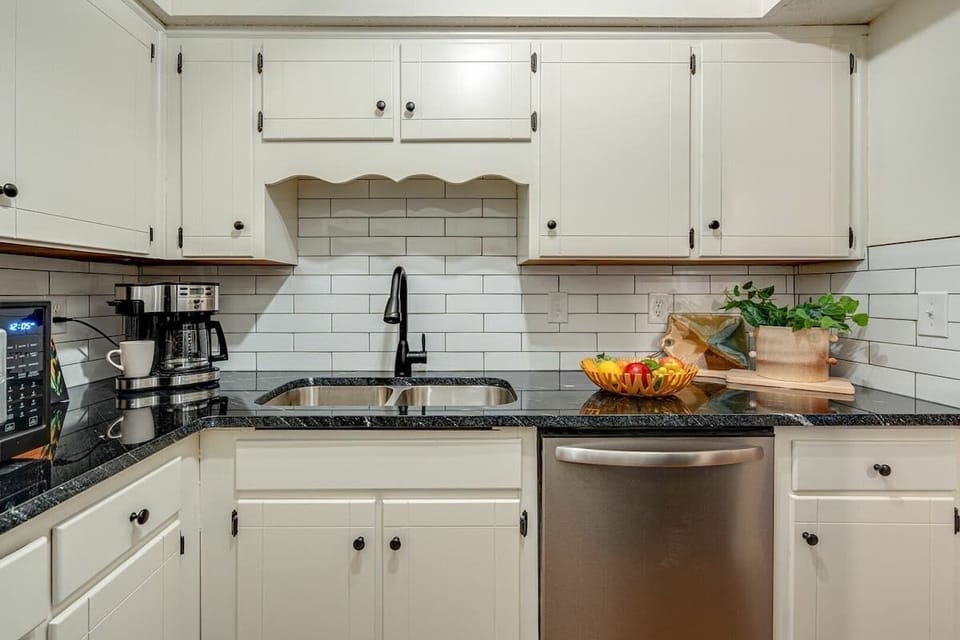 Full kitchen stocked with basic cooking essentials and stainless steel appliances.