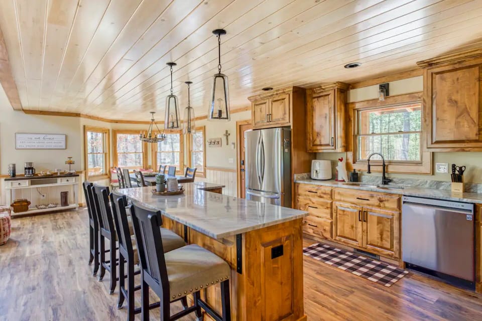 Fully equipped kitchen with stainless steel refrigerator, dishwasher, and oven.