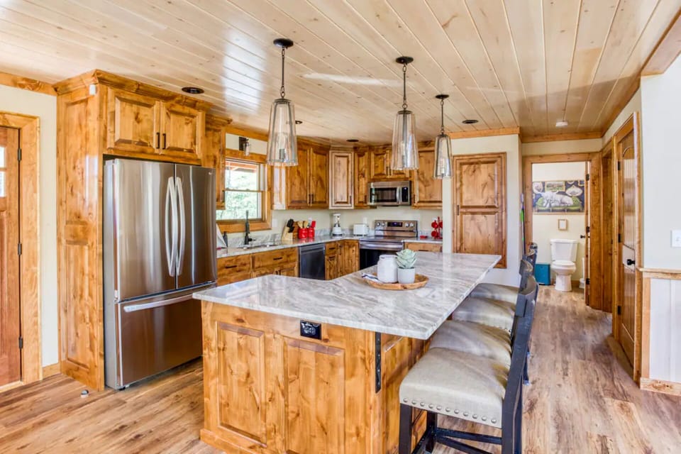 Large island for buffet or charcuterie with four additional bar stools.