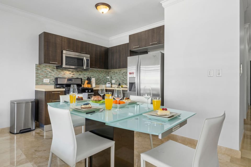 A sleek kitchen layout with a fridge, stove, oven, and microwave.