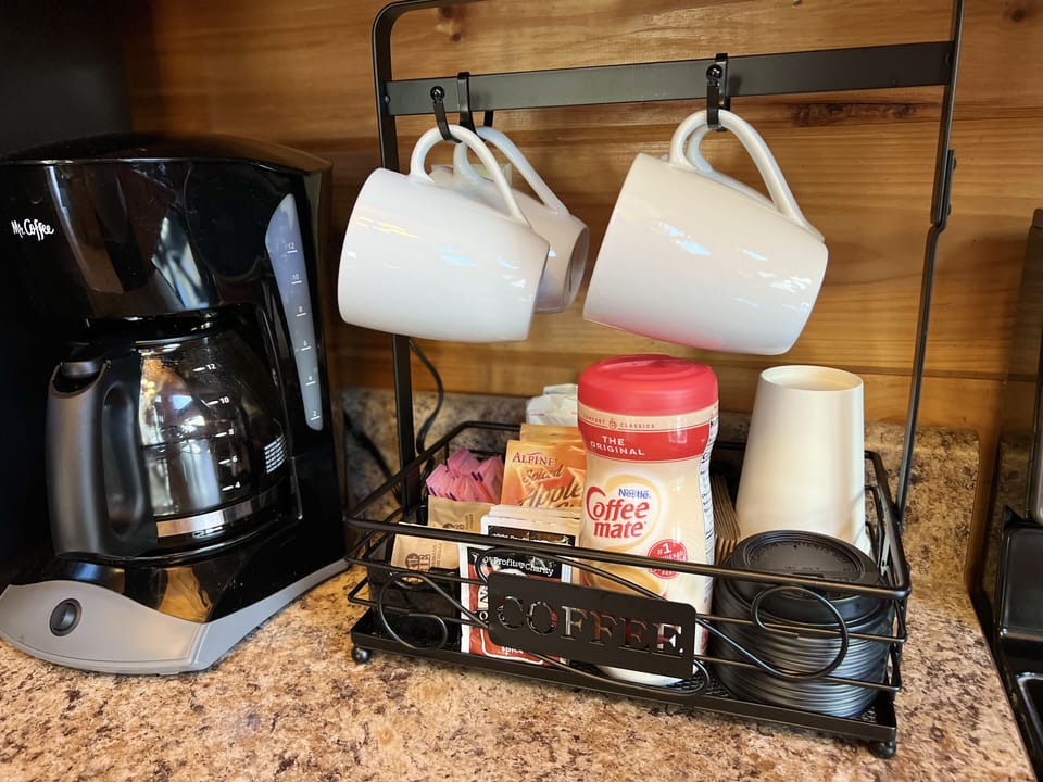 Coffee station equipped with to go cups, cider, hot chocolate and more