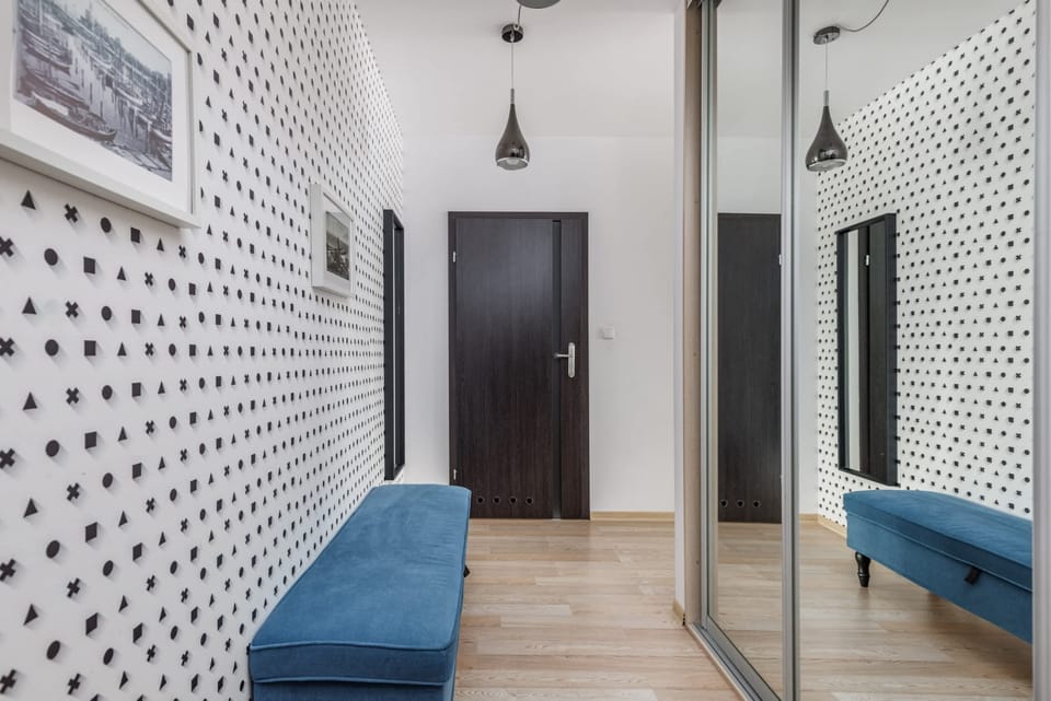 Hallway with a closet and mirror.