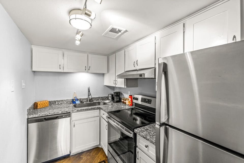 Modern kitchen area offering stainless appliances and granite countertops.